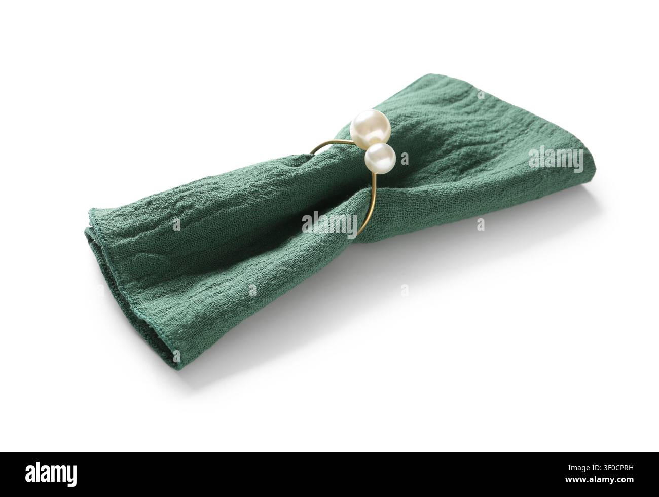 Grüne Stoffserviette mit Perlenserviettenring auf weißem Hintergrund Stockfoto