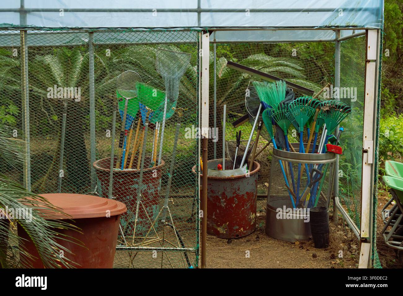 Gartenwerkzeugschuppen mit Rechen, Netzen und Landschaftsgartengeräten Stockfoto