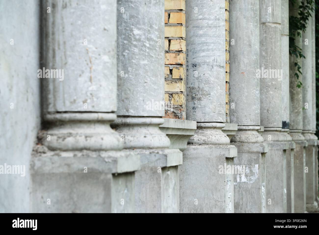 Perspektivische Ansicht von verwitterten klassischen Steinsäulen mit texturierter Mauerarbeit, die den architektonischen Rhythmus, historische Bau Details und ti hervorhebt Stockfoto