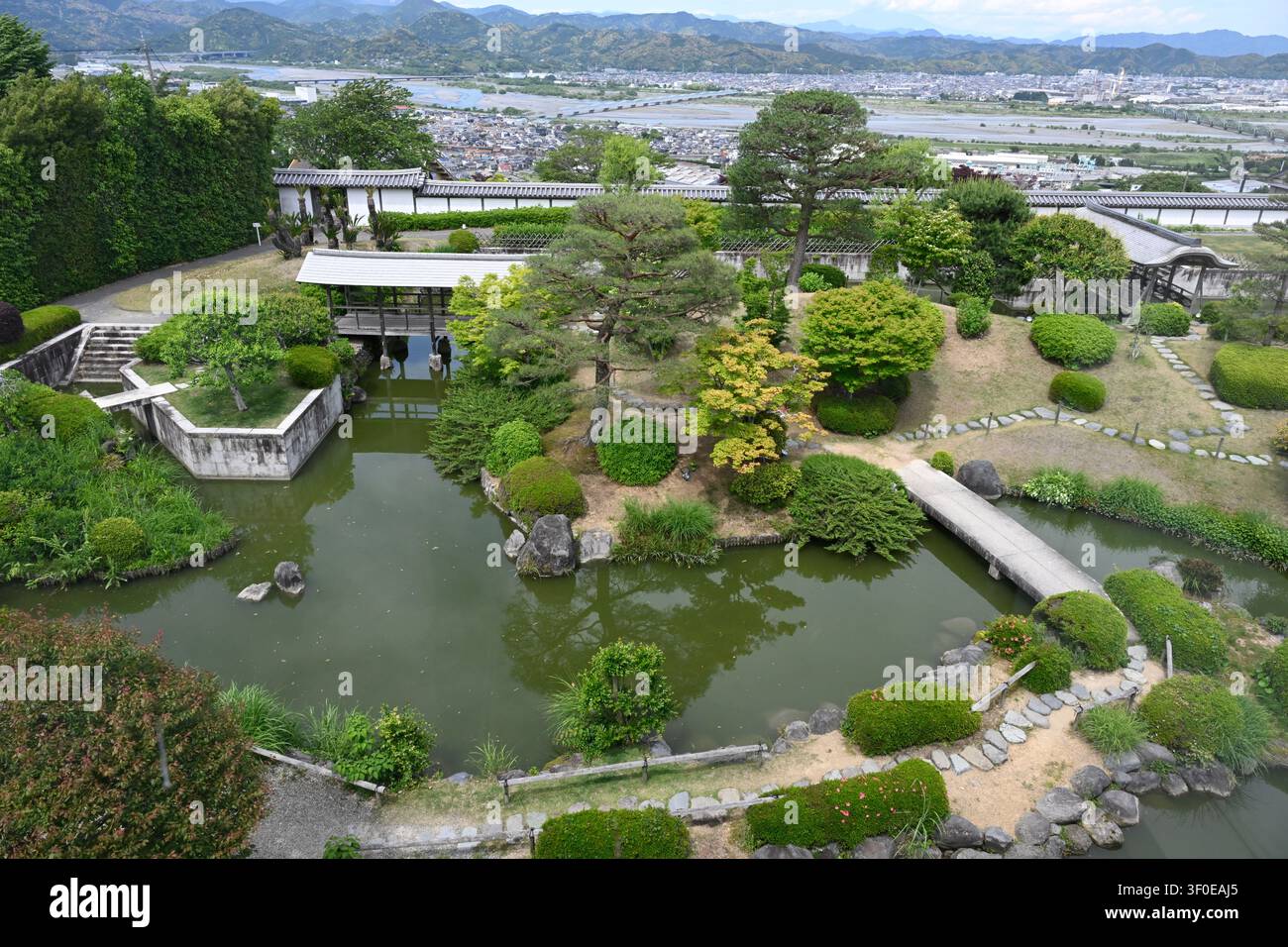 Panoramablick auf den traditionellen japanischen Garten im Fujinokuni-Teemuseum in Shizuoka, Japan. Mit einem Teich, Steinbrücken und sorgfältig geschnittenen Stockfoto