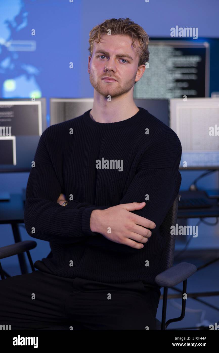 Männlicher Profi arbeitet in einem sicheren Operationszentrum mit Technologiemonitoren Stockfoto