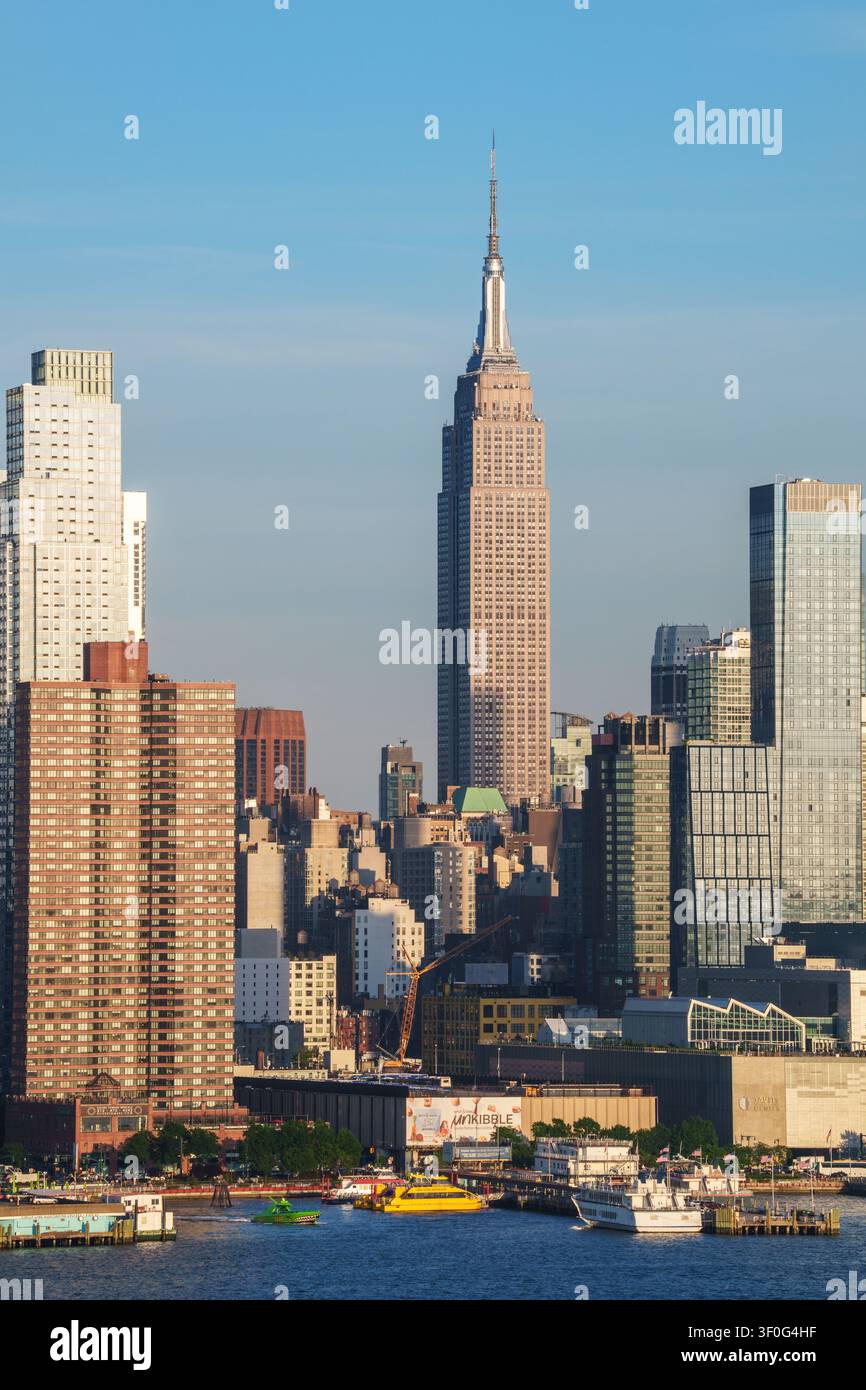 Empire State Building erhebt sich über der Skyline von New York City und den Wolkenkratzern von Manhattan auf der anderen Seite des Hudson River, New York, USA. Stockfoto