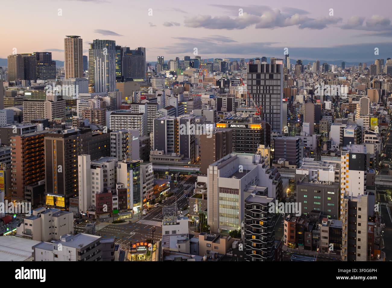 Erhöhte Weitwinkelansicht über eine dichte Metropolenlandschaft in der Dämmerung unter einem Zwielicht-Himmel, Osaka, Japan Stockfoto