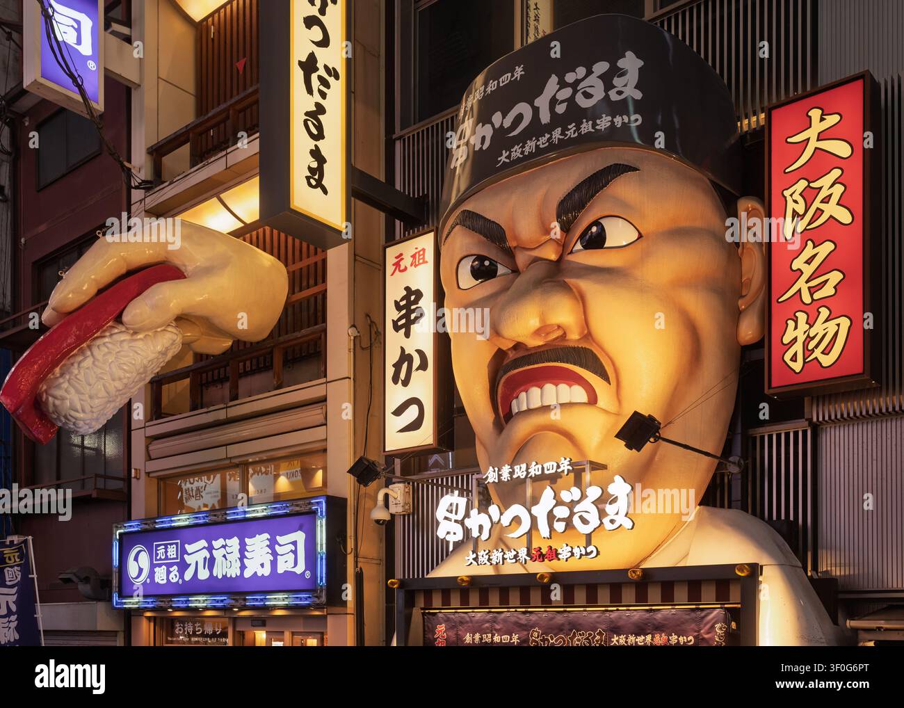 Nahaufnahme einer Straßenansicht eines riesigen plastischen Charaktergesichtmodells, das ein Izakaya-Restaurant in Osaka, Japan, bewirbt Stockfoto