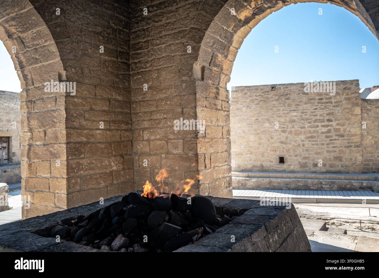 Alter steinerner Tempelbogen, der das ewige heilige Feuer umrahmt, ein Symbol des zoroastrischen Gottesdienstes und der Geschichte in Aserbaidschan Stockfoto