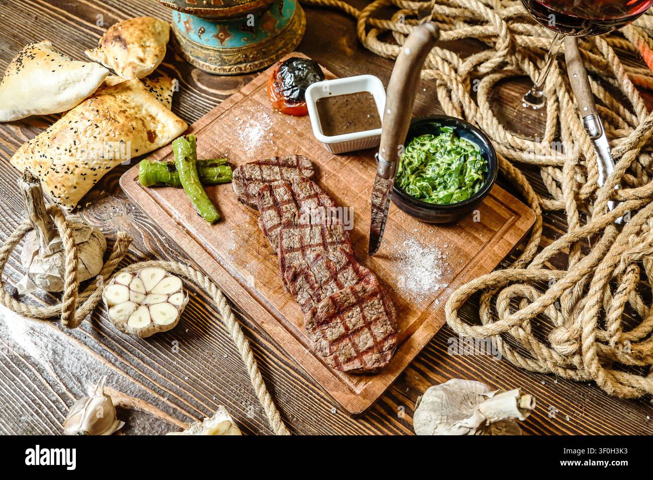 Ein Holzschneidebrett, das eine Auswahl an Fleisch- und Gemüsetoppings präsentiert. Stockfoto