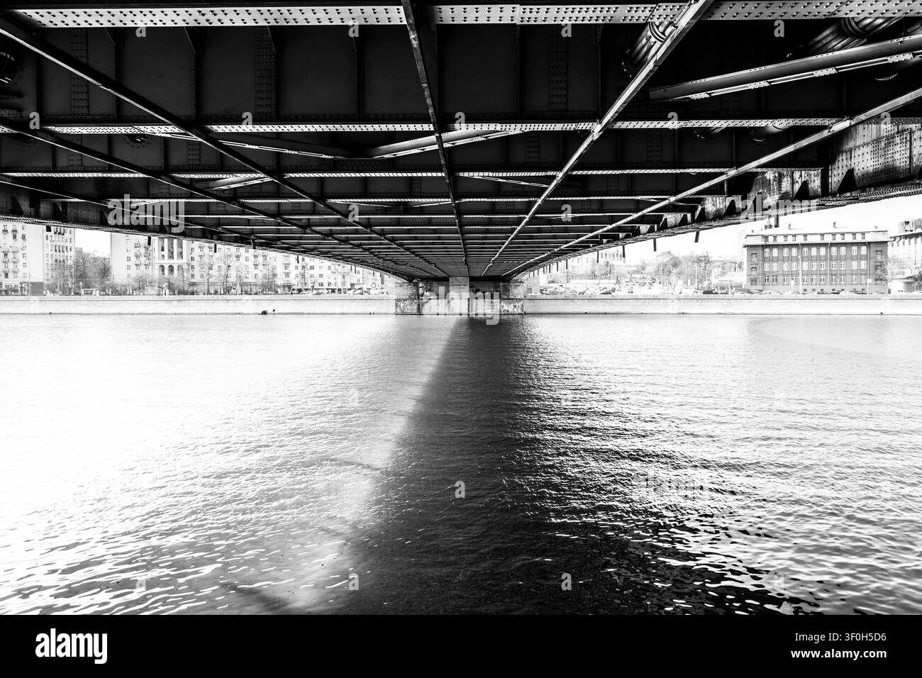 Perspektive mit niedrigem Wasserstand, die unter einer Stahlträger-Straßenbrücke hindurchschaut, die die Moskwa im Zentrum von Moskau, Russland, überspannt. Stockfoto