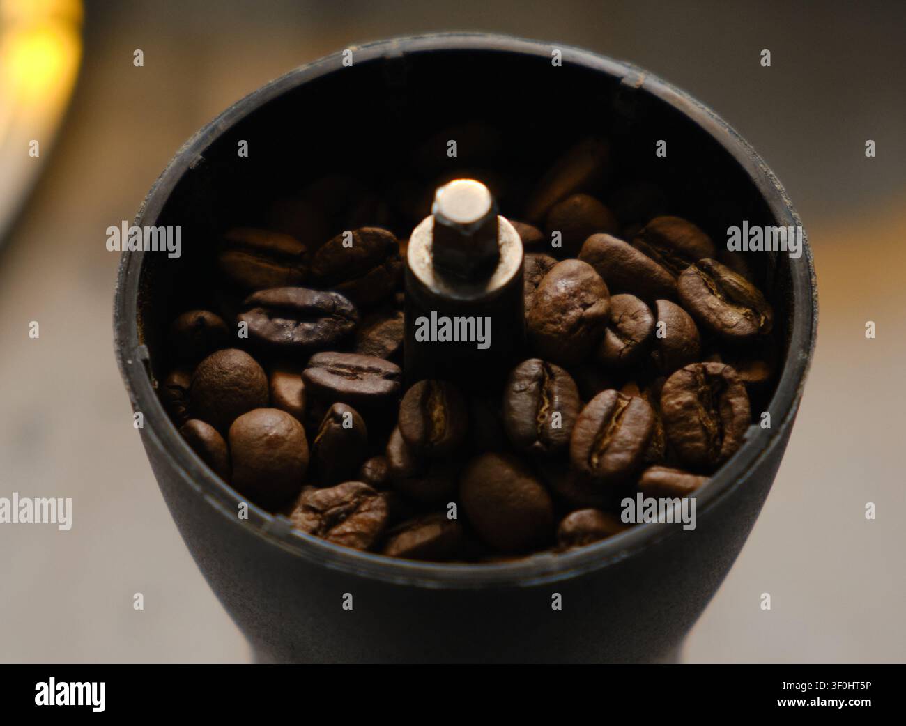 Nahaufnahme einer manuellen Kaffeemühle mit gerösteten Kaffeebohnen Stockfoto