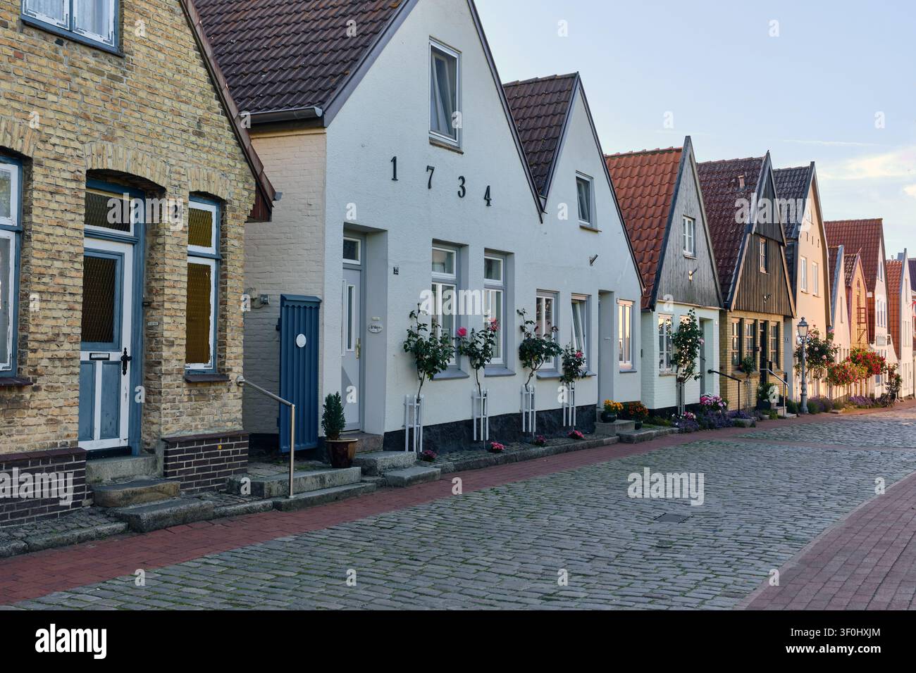 Historische Architektur und traditionelle Häuser im Fischerdorf Holm, Schleswig, Deutschland, bezaubernde Kopfsteinpflasterstraße und Wohngebiet, Geschichte Stockfoto