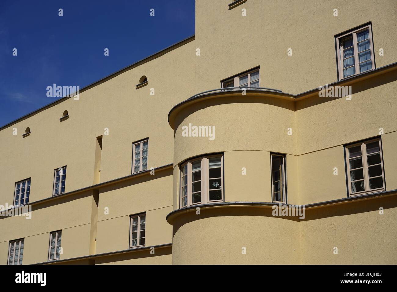 Magdeburg, Deutschland – 8. Juli 2026: Gebogene Eckfassade eines modernistischen Gebäudes in der Hermann-Beims-Siedlung, die von Bruno Taut geplant wurde. Stockfoto