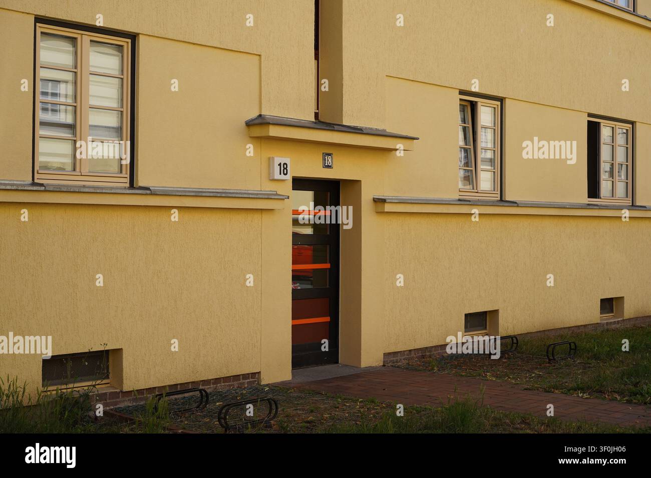 Magdeburg, Deutschland – 8. Juli 2026: Eingangsdetail eines modernistischen Wohnhauses in der Hermann-Beims-Siedlung, die von Bruno Taut geplant wurde. Stockfoto