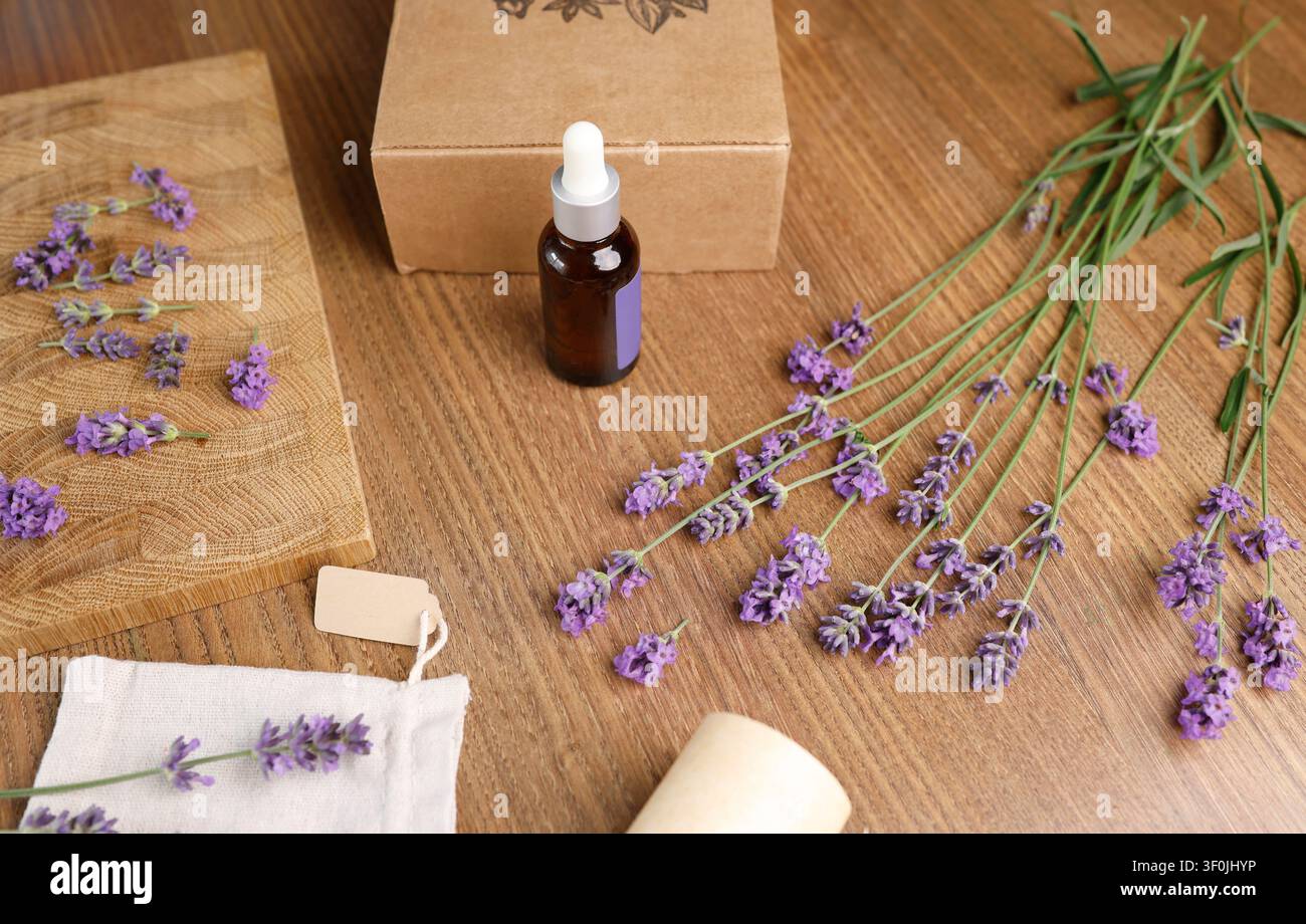Lavendelölflasche und Beutel mit Blumen auf Holzbrett. Flache Komposition für Social-Media-Content-Ersteller und Blogging-Hintergrund Stockfoto