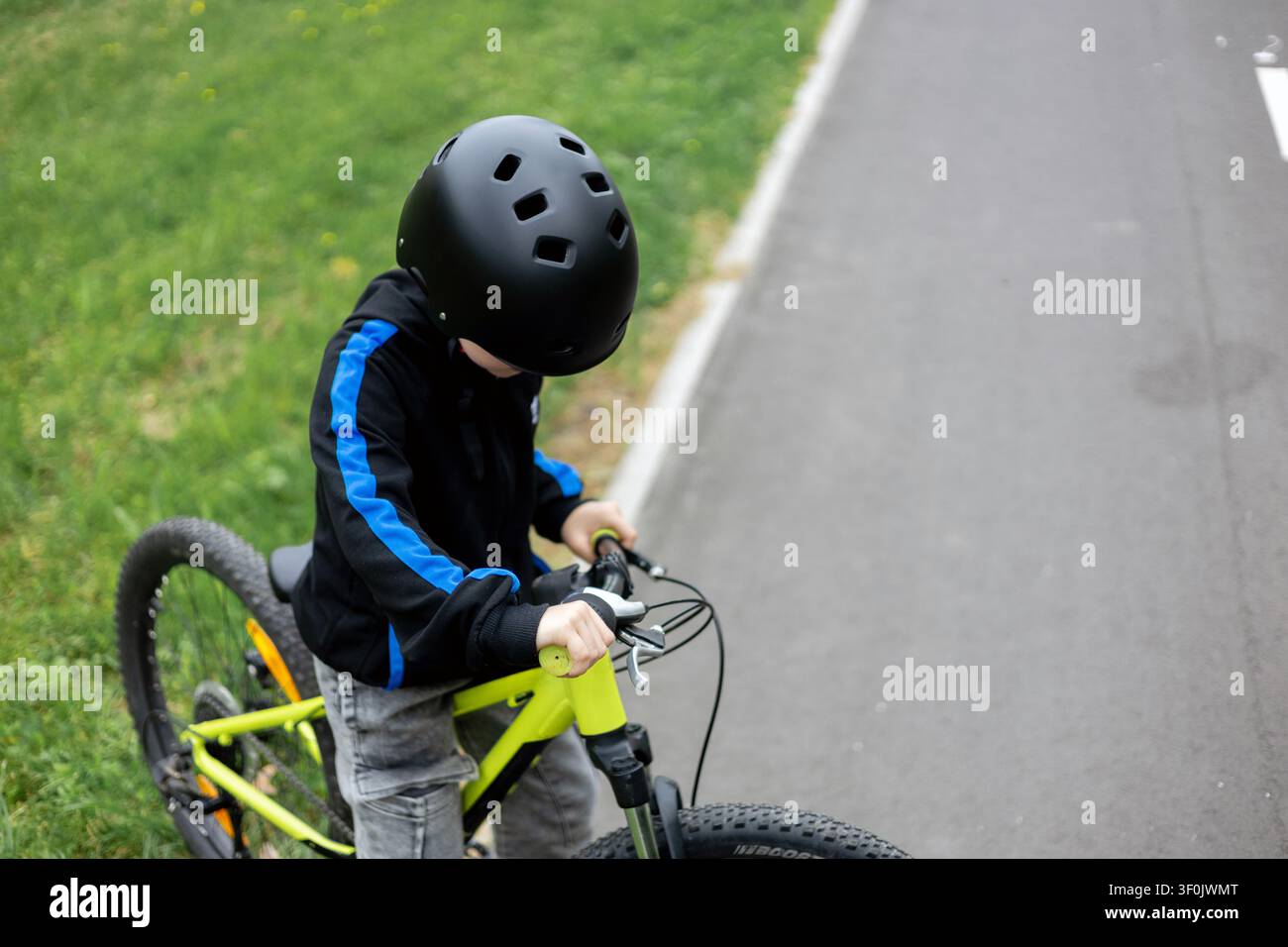 Hohe Blickwinkelansicht eines Jungen auf einem Neon-Fahrrad Stockfoto