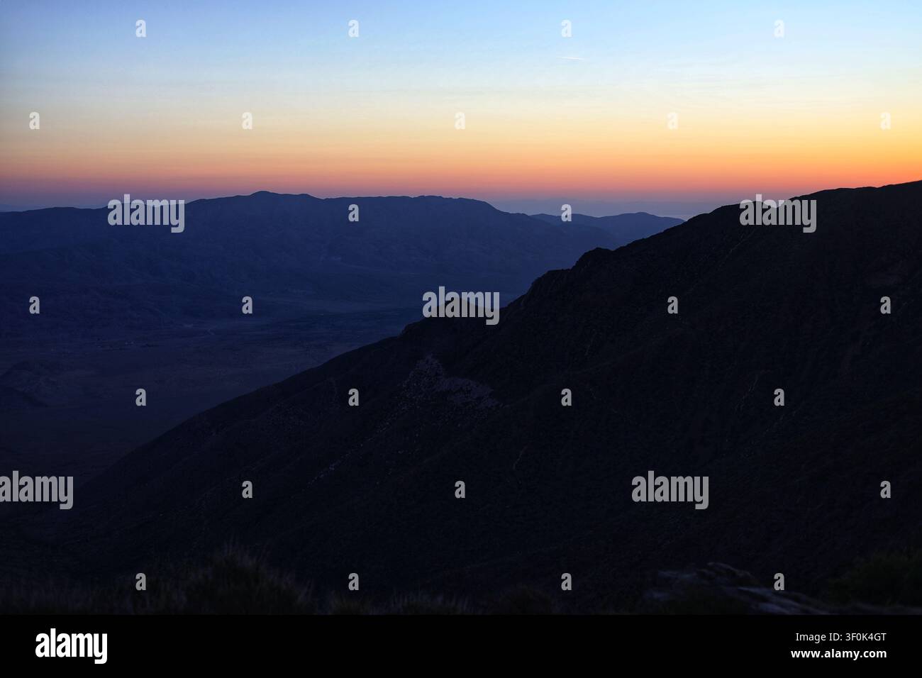 Schichtige Wüstenbergbilder unter einem weichen Morgenhimmel Stockfoto