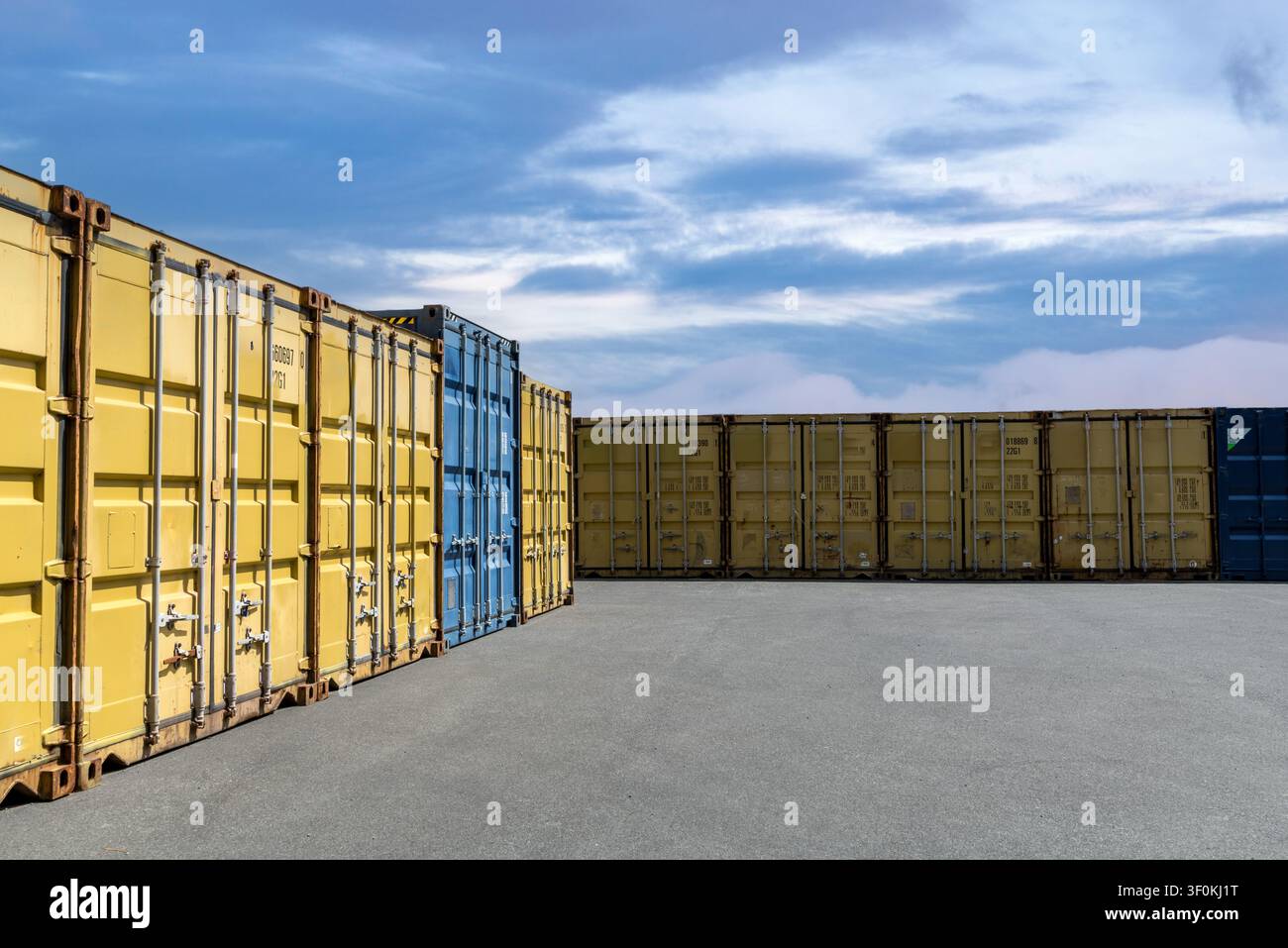 Autohintergrund, Automobil-Rückplatte, offener Parkplatz umgeben von Schiffscontainern. Stockfoto