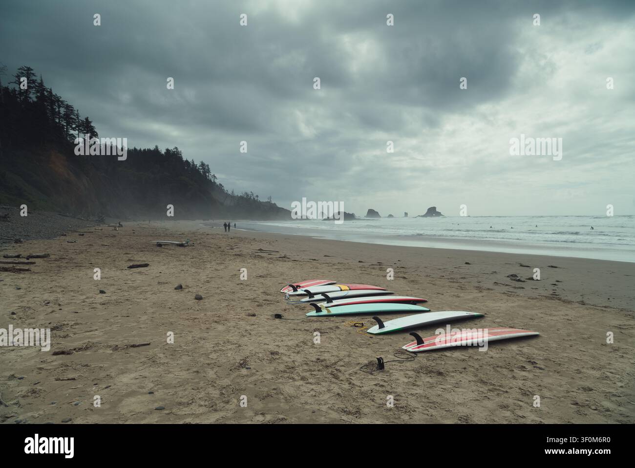 Atemberaubende Küste von Oregon mit Surfbrettern auf sandigem Strand vor dramatischem, stimmungsvollerem Himmel, Pazifischer Nordwesten, USA Stockfoto
