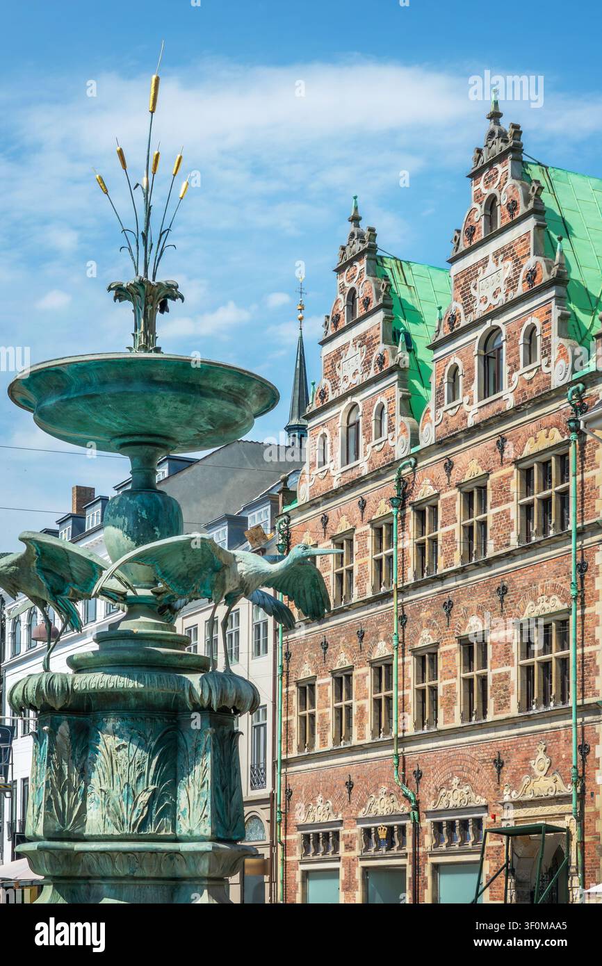 Der Storchbrunnen und ein altes Backsteingebäude auf dem Amagertorv-Platz im Zentrum von Kopenhagen, Dänemark Stockfoto
