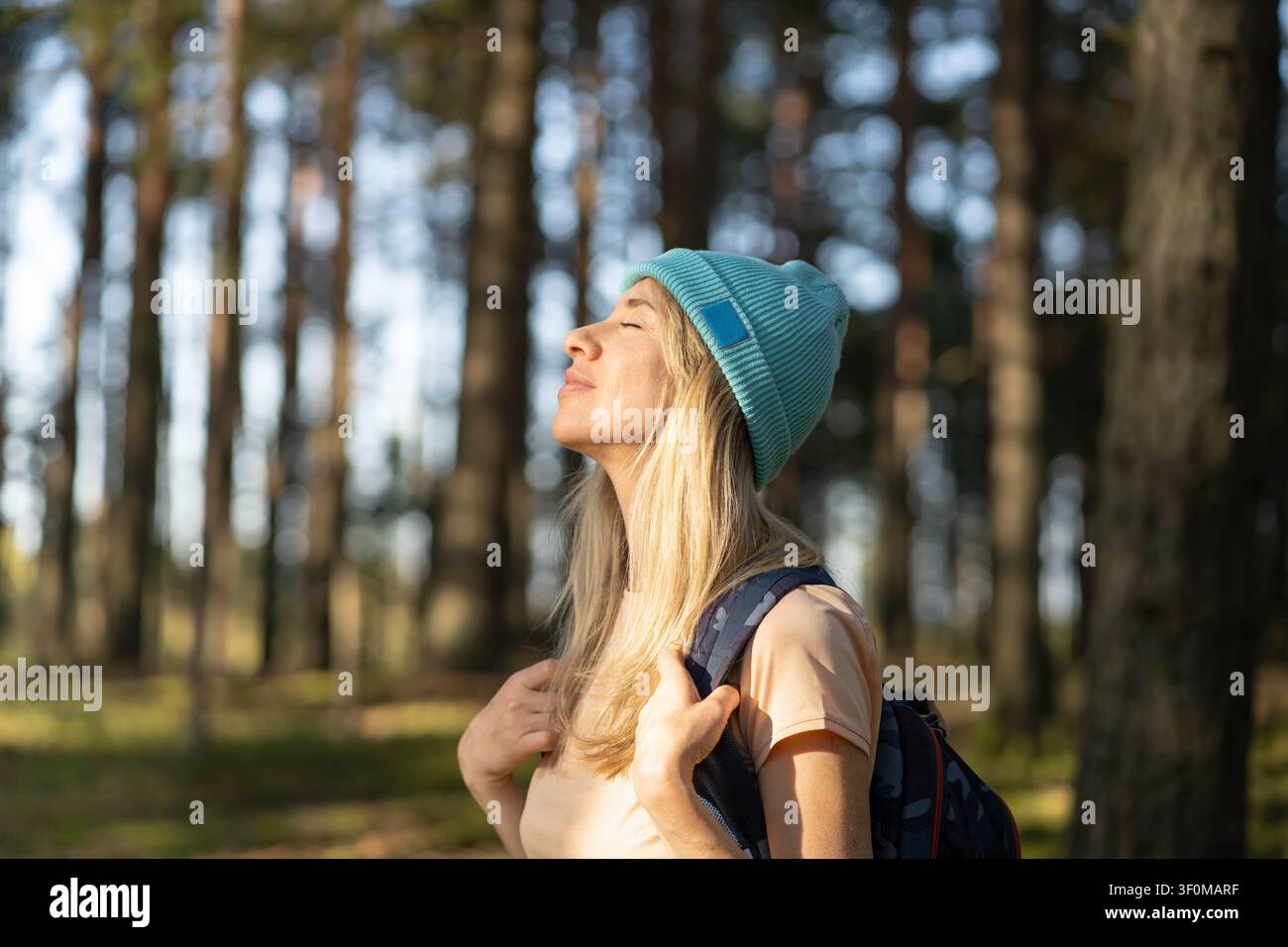 Naturflucht, Abkehr von der Routine und Entspannung, zufriedene Frau auf einem Waldspaziergang im Wald. Stockfoto