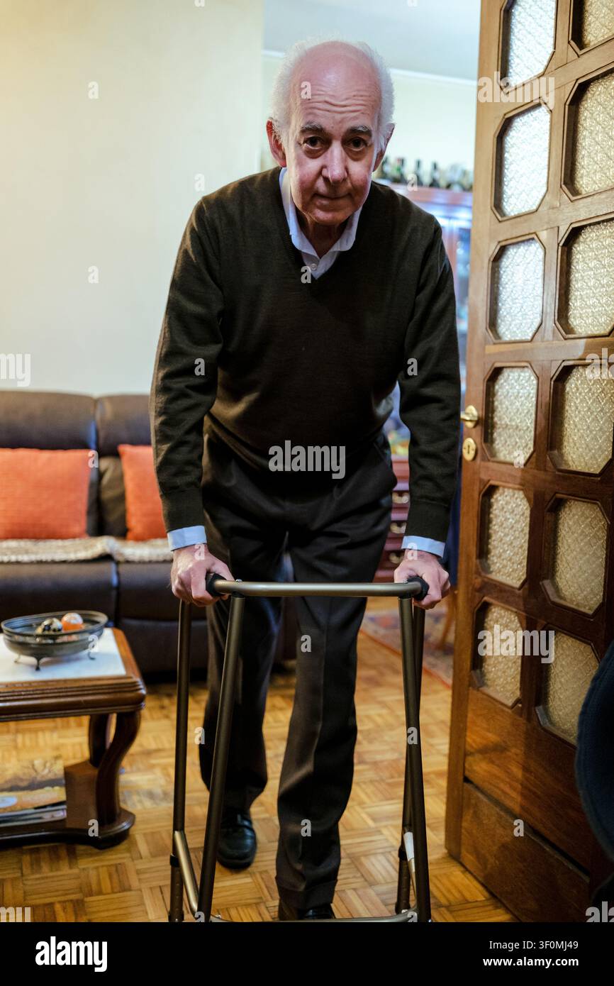 Senior Mann geht langsam mit Hilfe eines Gehgestelles in seinem Haus Stockfoto