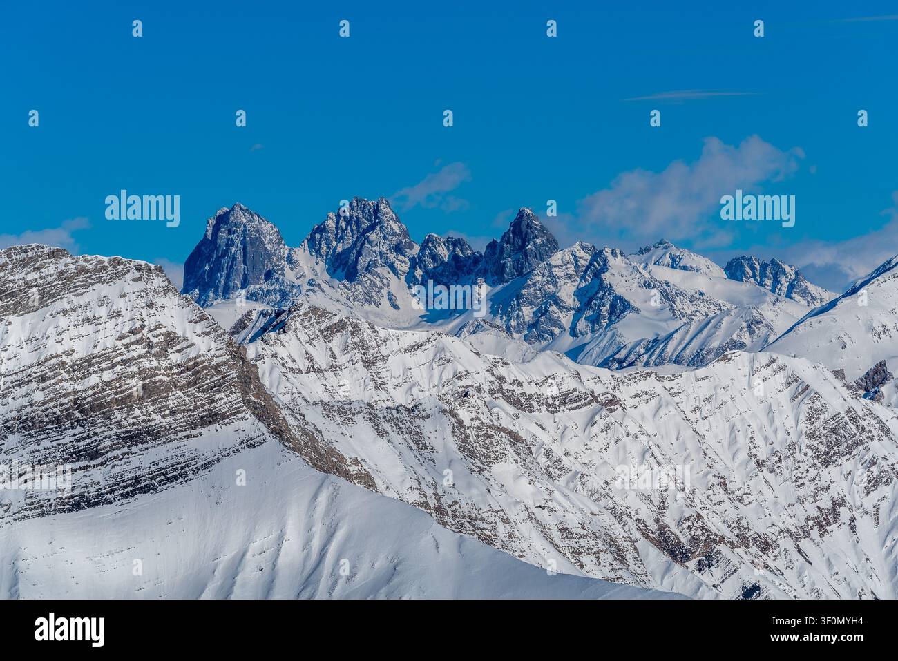 Eine Panoramansicht schroffer, schneebedeckter Gipfel, die über geschichteten Alpenkämmen im Großen Kaukasus aufragen Stockfoto