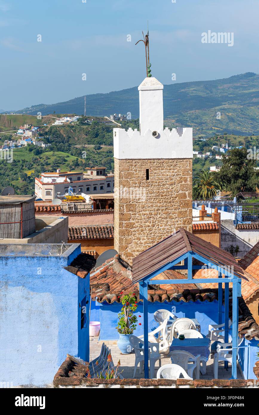 Das schlanke weiß-gegliederte Minarett der Sidi Bouhansa Moschee erhebt sich über den charakteristischen blauen Dächern und flachen Gebäuden der Medina, Rahm Stockfoto