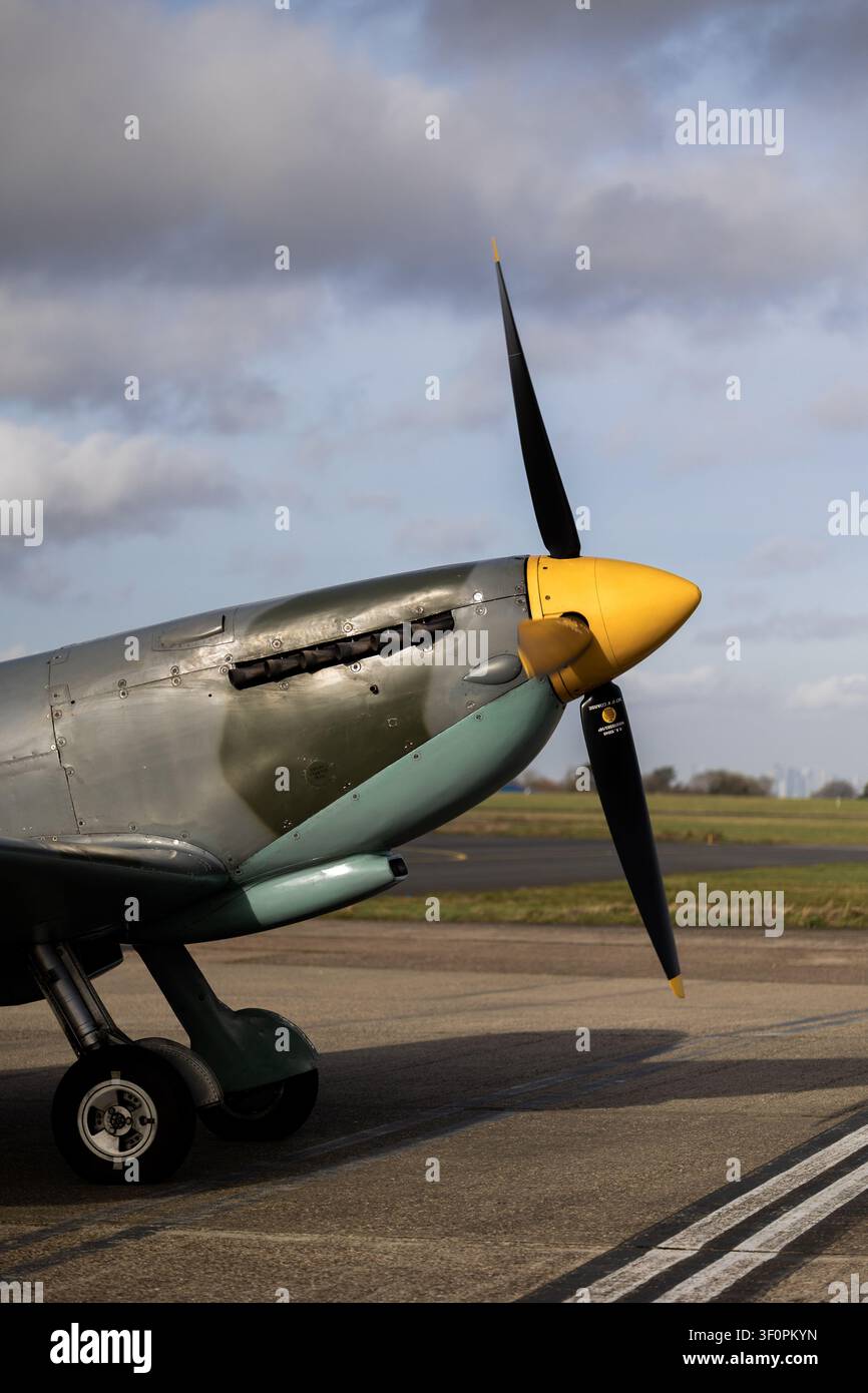 Nase einer Supermarine Spitfire mit gelbem Propellerknauf, Auspuffstielen und Dowty Rotol Propeller unter dramatischen Wolken am Biggin Hill Airport, Kent, England Stockfoto