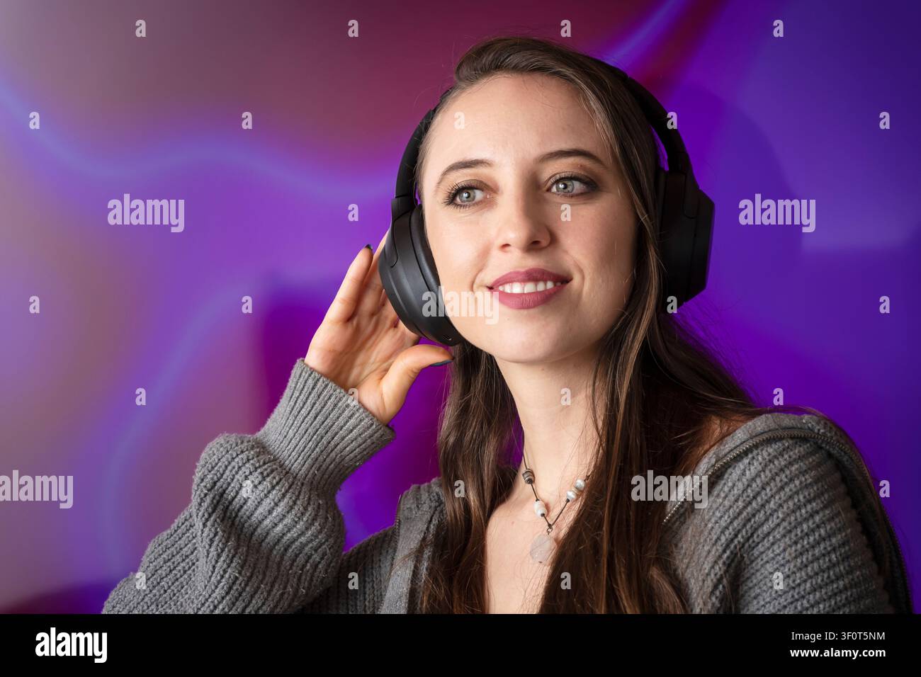 Junge Frau hört Musik mit kabellosen Kopfhörern Stockfoto