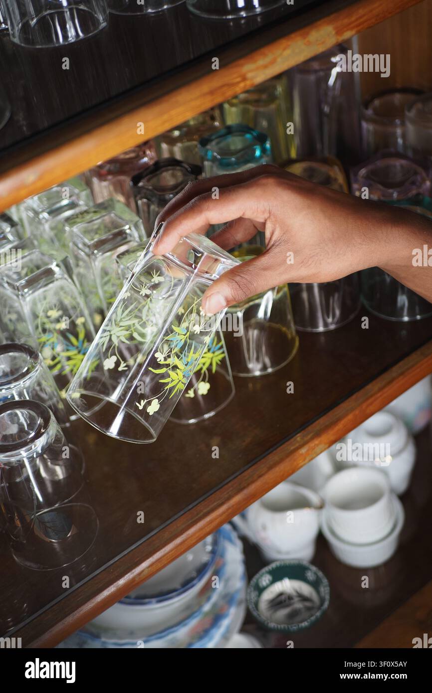 Wählt ein schönes Glas aus einer hellen Vitrine Stockfoto