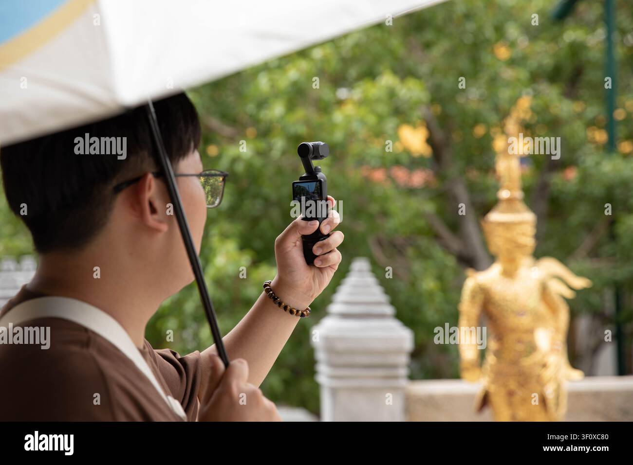 Mann, der Video mit einer 360-Grad-Kamera aufnimmt, Seitenprofil. Stockfoto