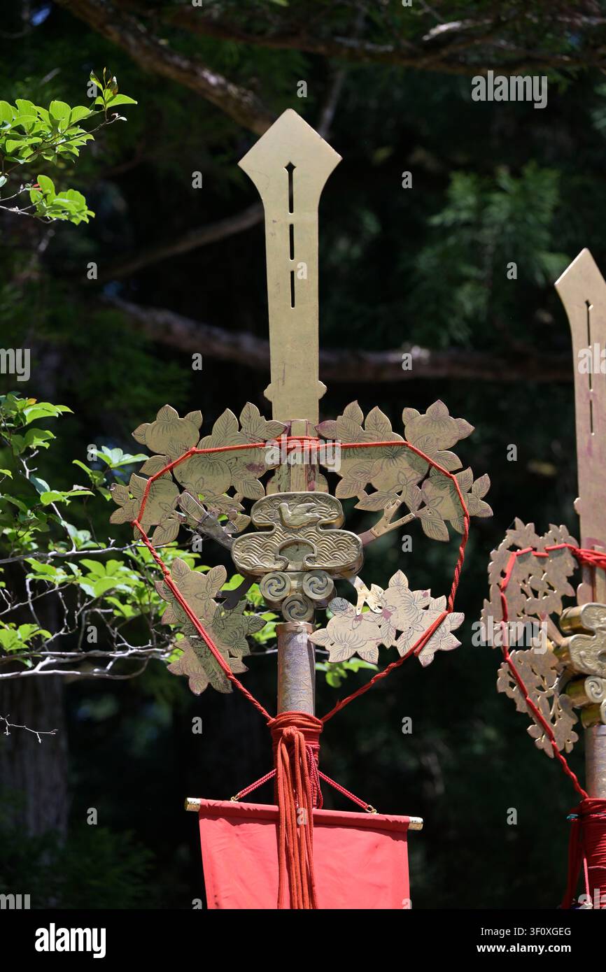 Nikko, Japan – 18. Mai 2026: Eine Nahaufnahme einer verzierten zeremoniellen Standarte, die mit vergoldeten Malvenblättern und einer roten Fahne geschmückt ist, während der Hyakumono- Stockfoto