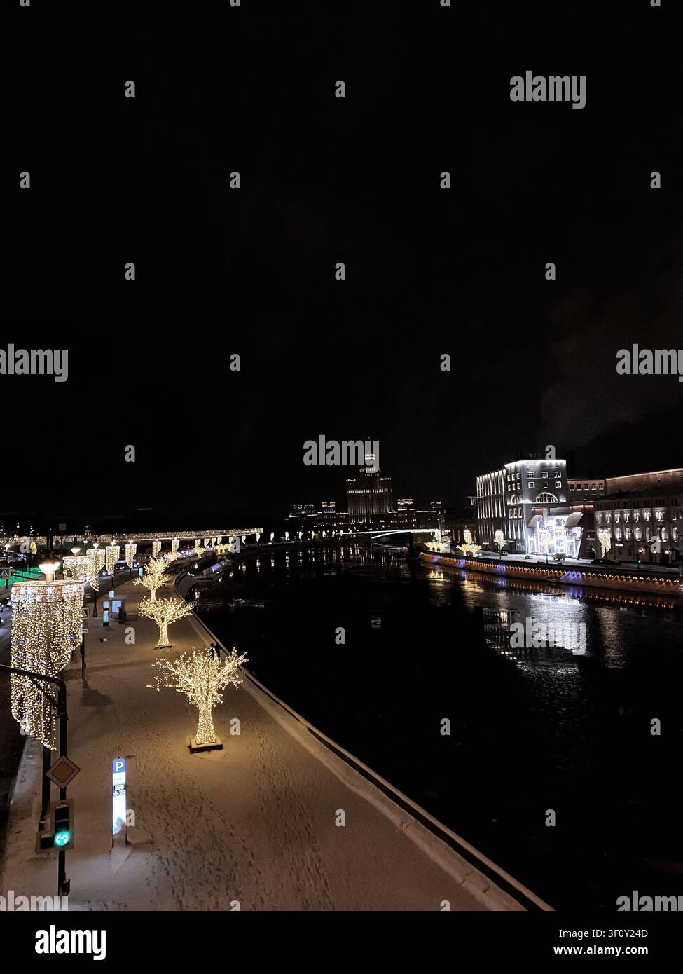 Moskau, Russland - 22. Januar 2022: Festliche beleuchtete Uferpromenade und Flussufer-Stadtlandschaft während der Winternacht in Moskau Stockfoto
