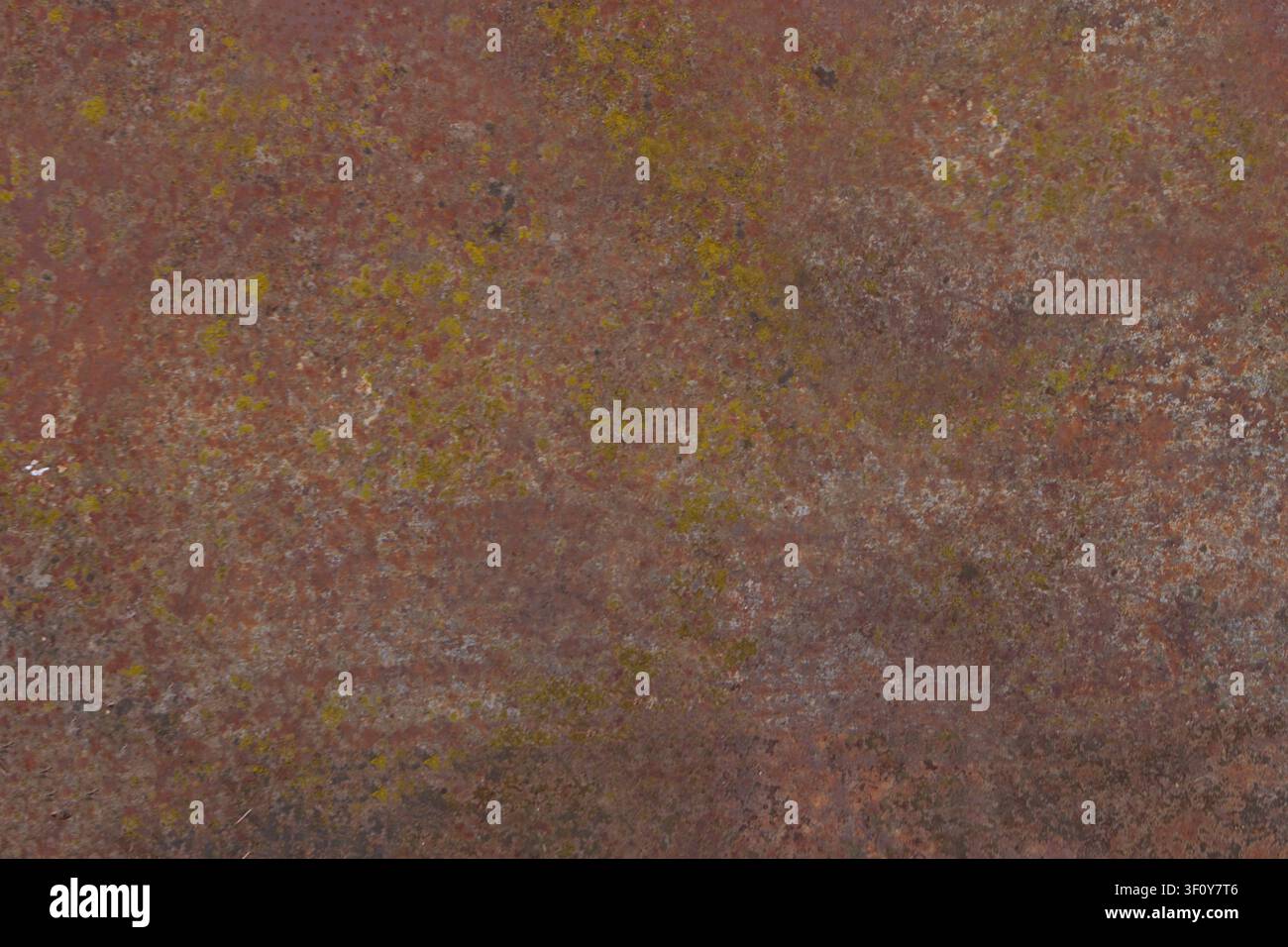 Nahaufnahme einer verwitterten, verlassenen Eisenblechoberfläche, bedeckt mit rötlich-braunem Rost, alter verfallender Farbe und Flecken von grünem Moos oder Flechten. Stockfoto