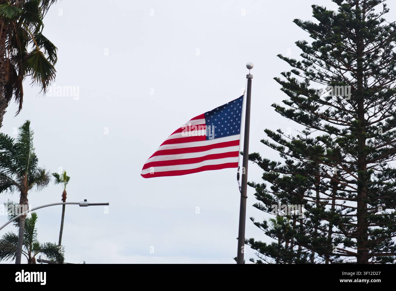 Amerikanische Flagge, die zwischen Küstenbäumen in Encinitas, Kalifornien, weht Stockfoto