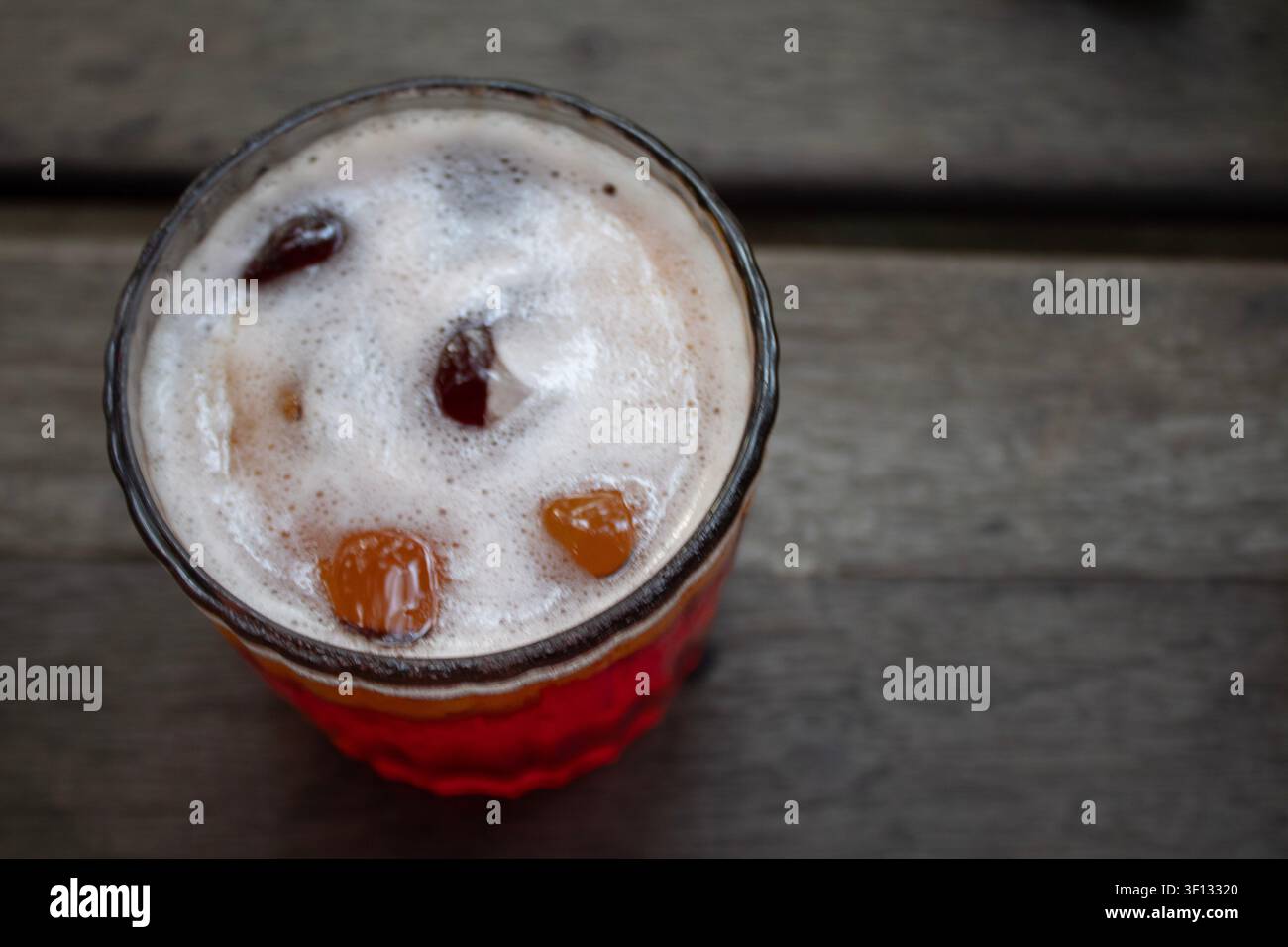 Oberblick auf einen Erdbeer-Cocktail oder Mocktail mit Zitronenscheibe auf einem Holztisch Stockfoto