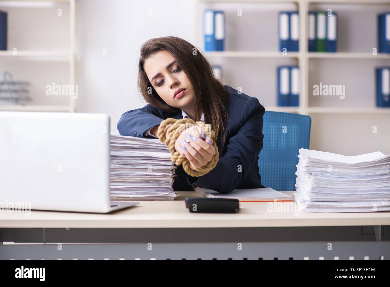 Junge schöne Mitarbeiter gebunden mit Seil im Büro Stockfoto