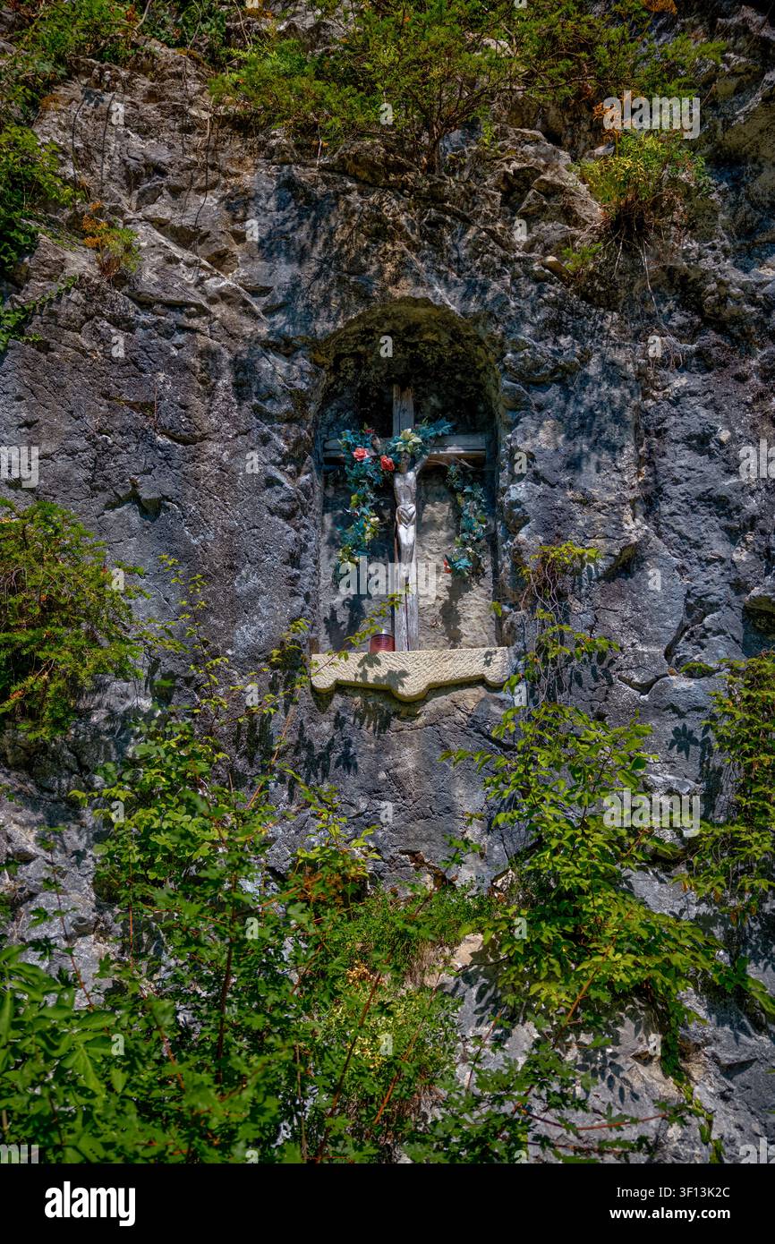Kleiner religiöser Schrein in einer felsigen Klippe in der Nähe des Olympischen Ruderzentrums am Bledsee in Slowenien. Stockfoto