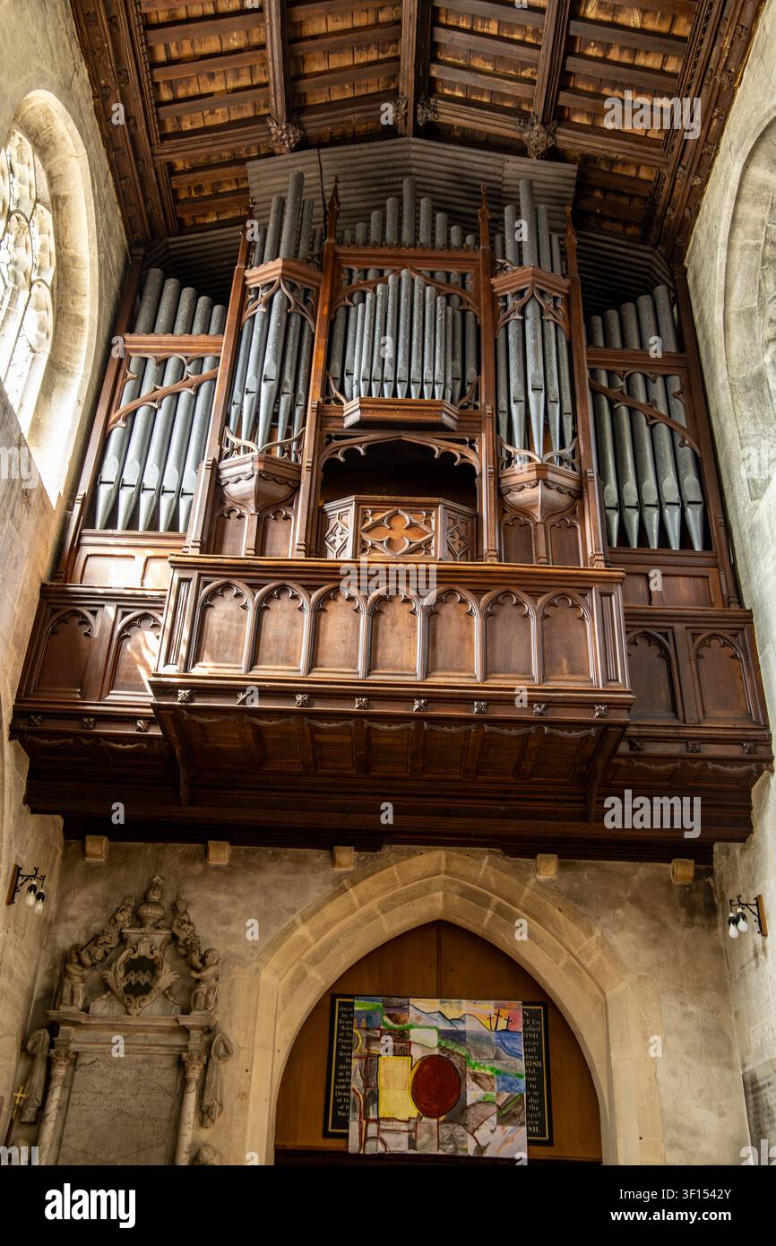 Ein Blick nach oben zu einer großen historischen Orgel, die in der Empore einer alten Steinkirche installiert ist. Holy Cross Church Wiltshire Stockfoto