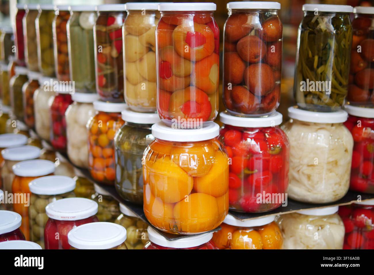 Farbenfrohe Gläser mit konserviertem Obst und Gemüse Stockfoto