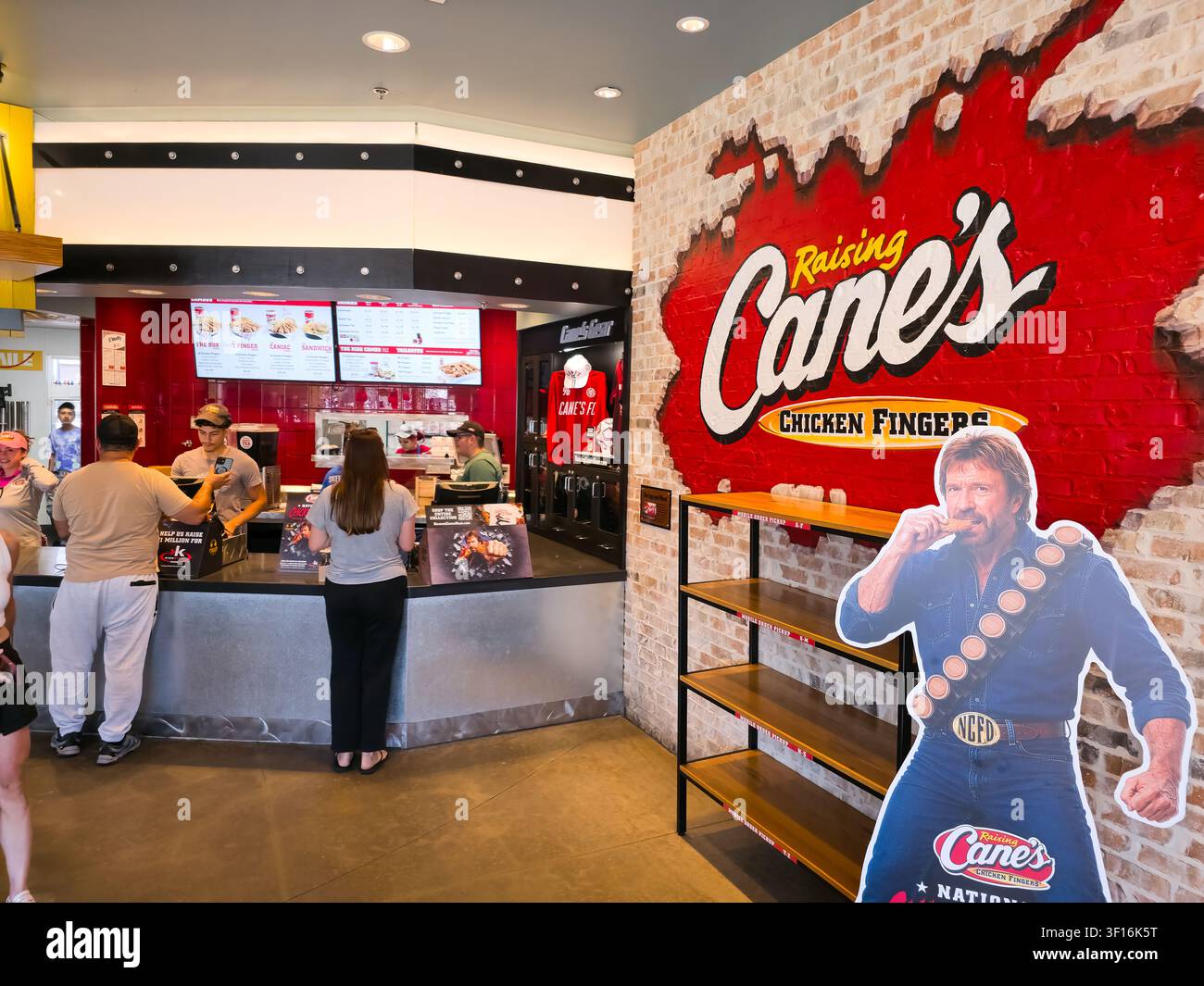 DALLAS, TX, USA - 10. JULI 2026: Kunden bestellen Essen an der Theke eines Raising Cane's-Restaurants. Raising Cane's ist eine amerikanische Fast-Food-Kette, die  Stockfoto