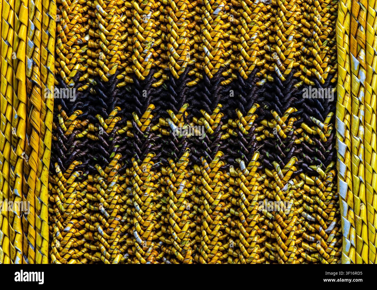 Nahaufnahme eines traditionellen handgewebten Musters mit gelber und schwarzer geometrischer Textur, ideal als ethnischer Hintergrund und Kunsthandwerksdesign. Stockfoto