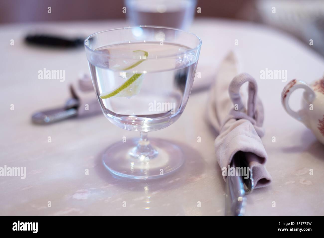 Ein Glas kühles Wasser mit einer Limettenscheibe in einem Restaurant Stockfoto