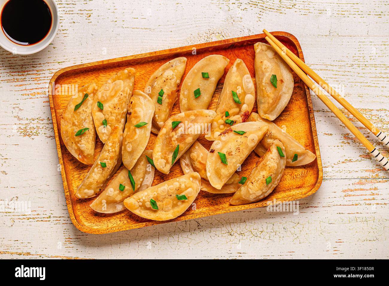 Knödel auf einem Holzteller mit Essstäbchen und Sojasauce, Ansicht von oben. Stockfoto