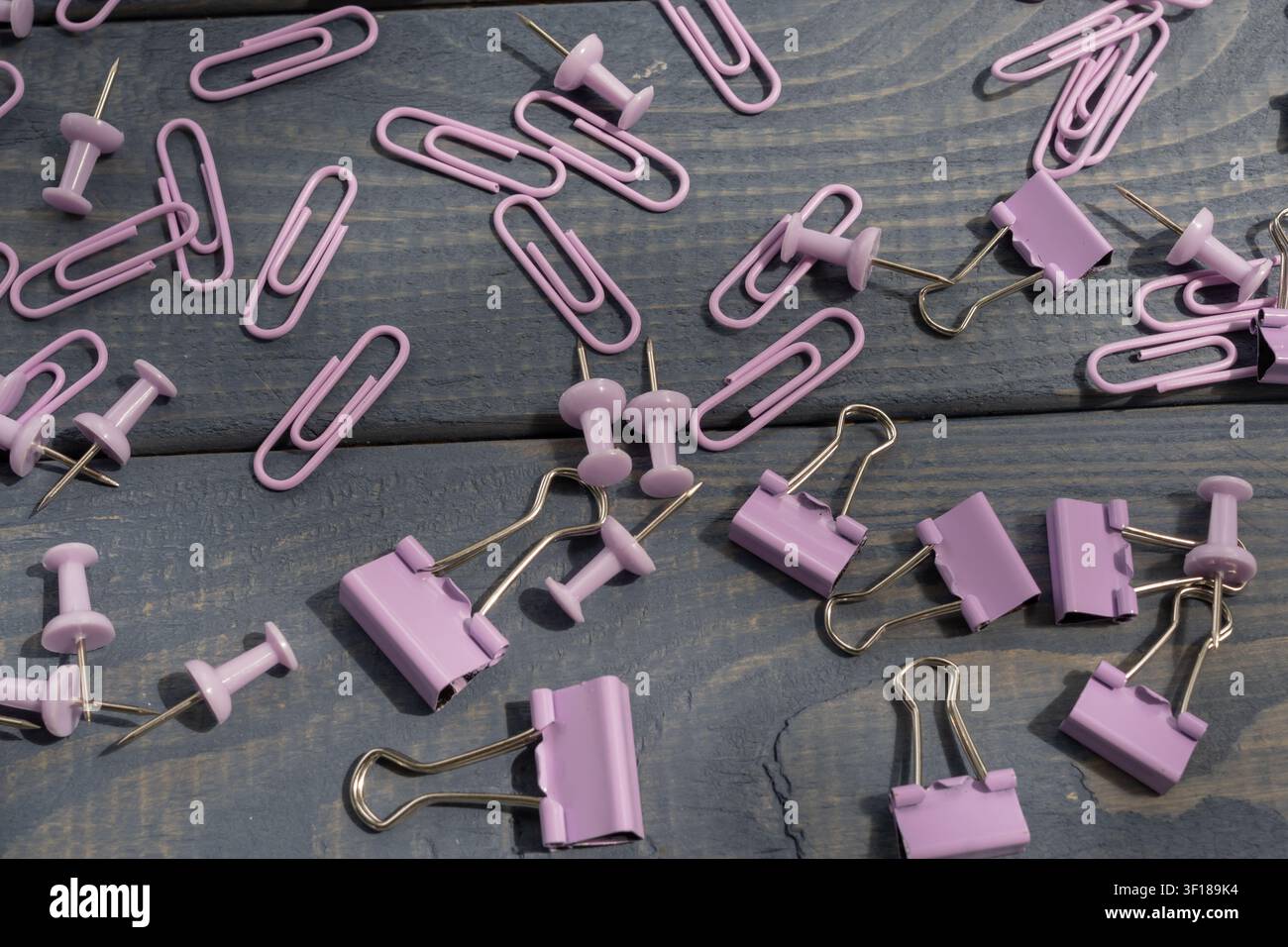 Pastellfarbene Büroaccessoires inklusive Büroklammern, Hefterklammern, Reißnadeln und Stifte für die Büroorganisation, Lern- und Schulbedarf. Stockfoto