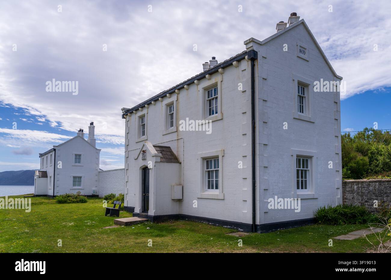 Die historischen Leuchtturmwächterhäuser von 1839 stehen entlang der Schotterstraße in der Nähe von Penmon Point in Anglesey. Stockfoto