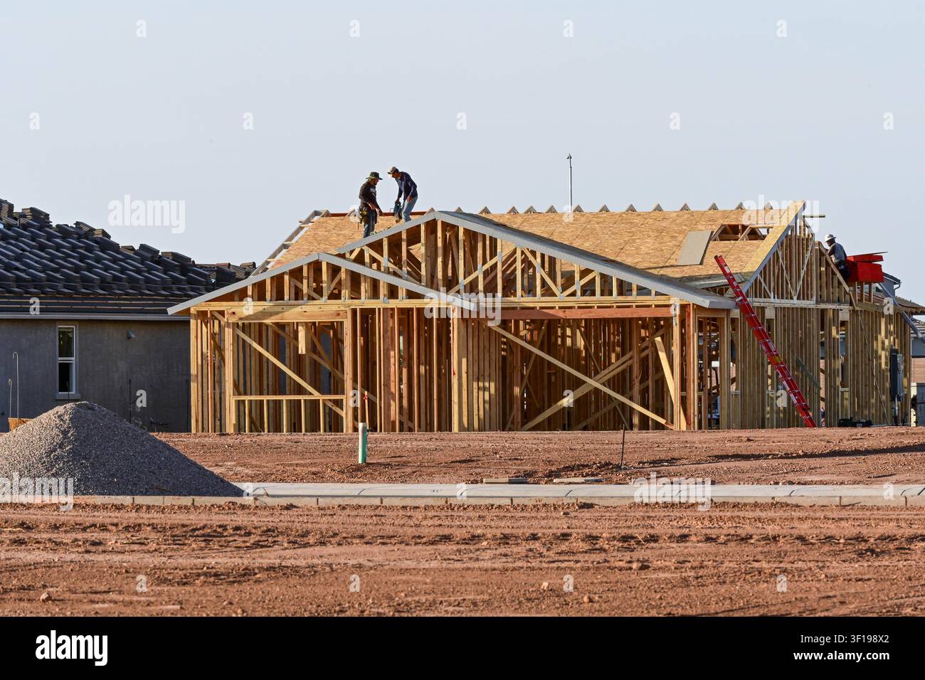 Apache Junction, Arizona, USA. 11. Juli 2026. Arbeiter bauen ein Einfamilienhaus in einer Wohnsiedlung in Pinal County, Arizona. Der Bau von Einfamilienhäusern in den USA ist kürzlich auf einen Achtmonatstief gefallen, da hohe Hypothekenzinsen und gestiegene Baukosten weiterhin die neue Wohnungsbauaktivität belasten. Trotz des nationalen Rückgangs geht die Wohnsiedlungsentwicklung in Zentralarizona weiter, während Bauunternehmer daran arbeiten, das langfristige Bevölkerungswachstum und den Wohnungsbedarf zu decken. (Bildnachweis: © Eduardo Barraza/ZUMA Press Wire) NUR FÜR REDAKTIONELLE NUTZUNG! NICHT FÜR KOMMERZIELLE NUTZUNG! Stockfoto