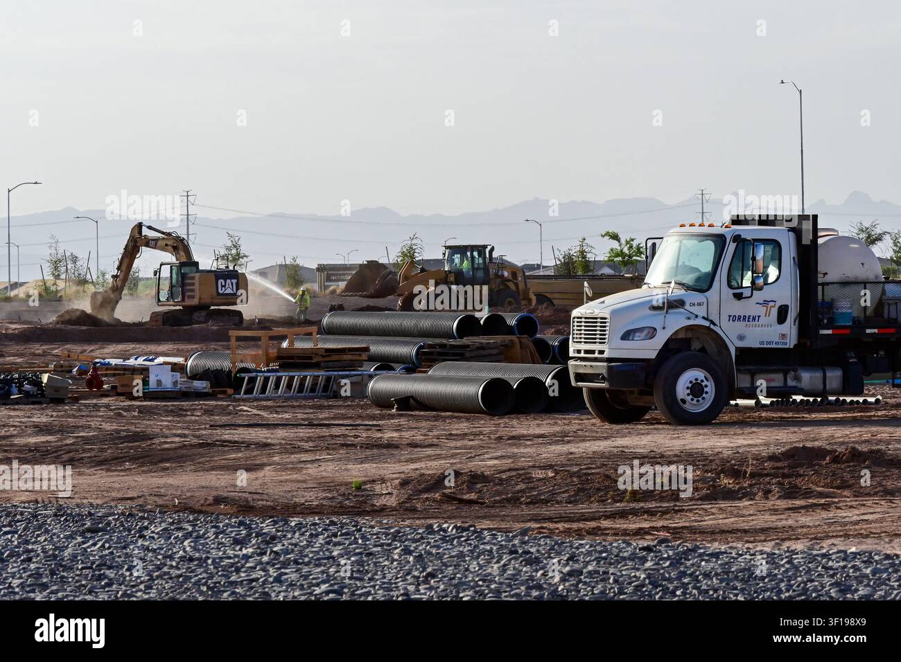 Apache Junction, Arizona, USA. 11. Juli 2026. Baugeräte und Arbeiter bereiten Land für eine neue Wohnsiedlung in Pinal County, Arizona, vor. Der Bau von Einfamilienhäusern in den USA ist kürzlich auf einen Acht-Monats-Tiefstand gefallen, da erhöhte Hypothekenzinsen und höhere Baukosten weiterhin den Neubau von Wohnungen belasten. Trotz des nationalen Abschwungs geht die Wohnentwicklung in Zentral-Arizona weiter, da Bauunternehmer daran arbeiten, das langfristige Bevölkerungswachstum und die Wohnnachfrage zu decken. (Bildnachweis: © Eduardo Barraza/ZUMA Press Wire) NUR FÜR REDAKTIONELLE VERWENDUNG! Nicht für kommerzielle VERWENDUNG! Stockfoto