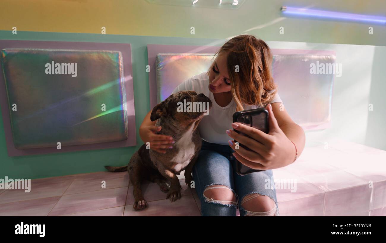 Junge Frau macht ein Selfie mit ihrem Hund zu Hause Stockfoto