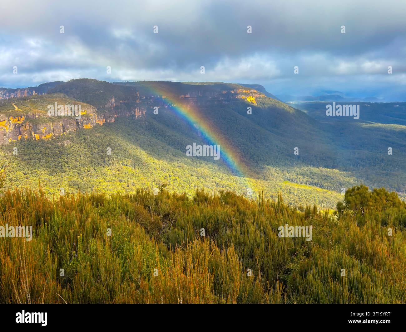 Fotografie eines farbenfrohen Regenbogens über dem Narrow Neck Plateau im Megalong Valley, gesehen vom Cahills Lookout nahe der Stadt Katoomba im Blue Mount Stockfoto