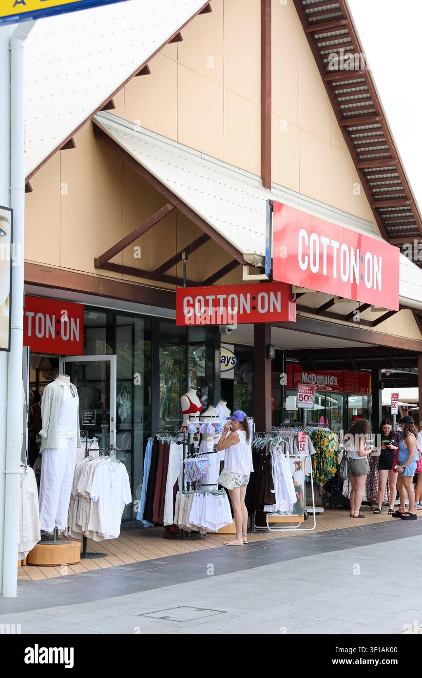 Einkäufer durchstöbern Kleiderständer vor der Fassade eines Cotton On-Einzelhandelsgeschäfts an einem sonnigen Tag in Queensland, Australien Stockfoto