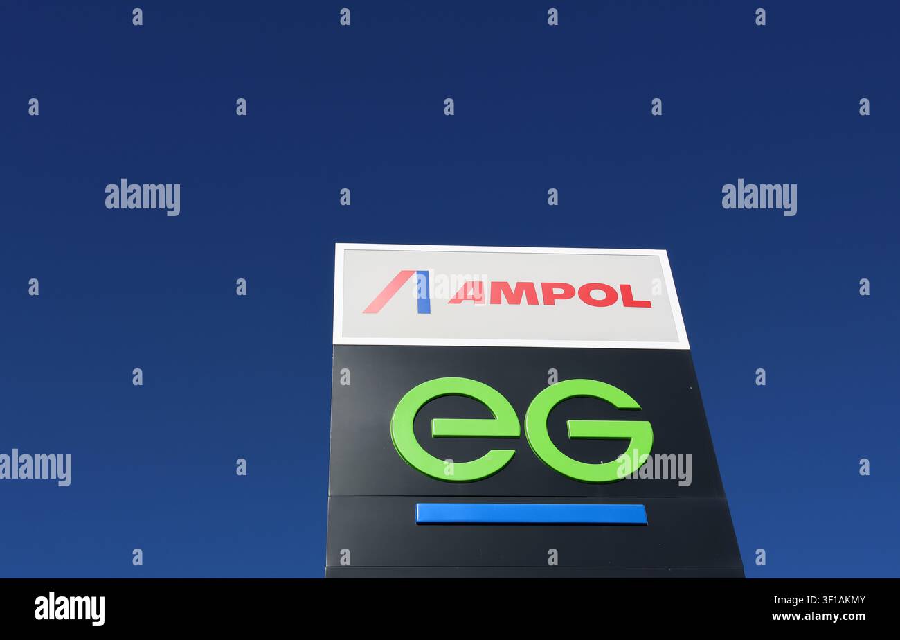 Eine Außenaufnahme aus niedriger Perspektive eines hellen Ampol- und EG-Markenschilds vor einem klaren blauen Himmel Stockfoto